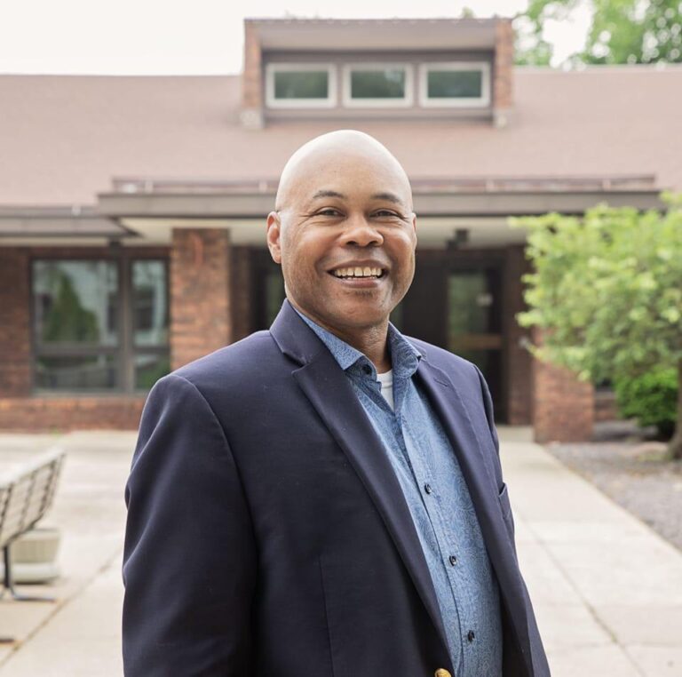 Samuel Hall III stands in front of a building.